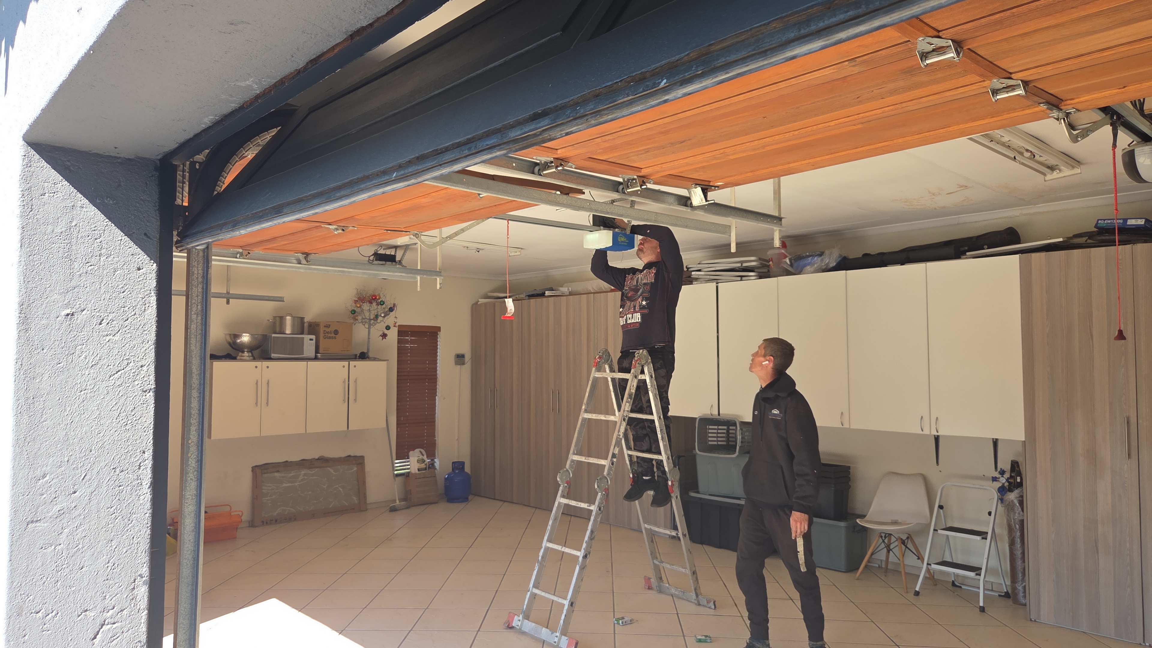 Absolute Shutter technician installing a garage door motor