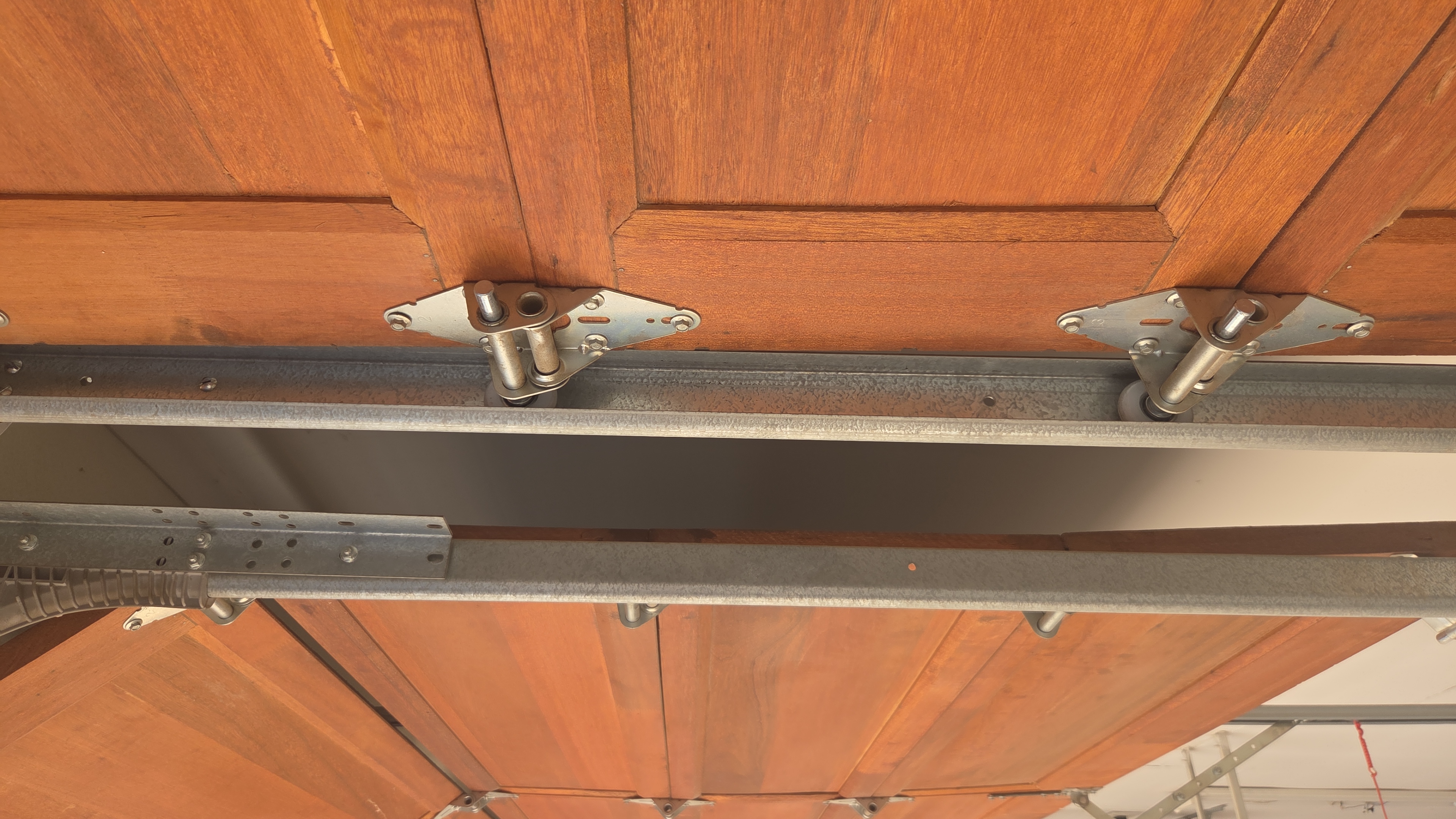 Wooden sectional garage door tracks and rollers